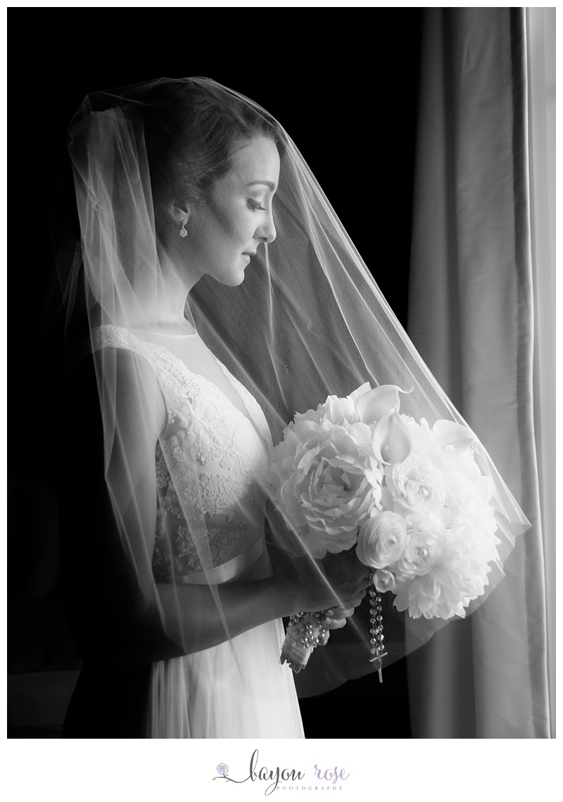 Bride holding bouquet at window