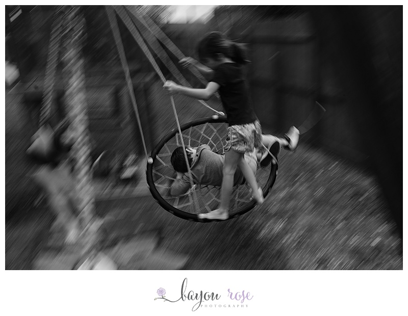 girl swinging brother with feet, with motion blur