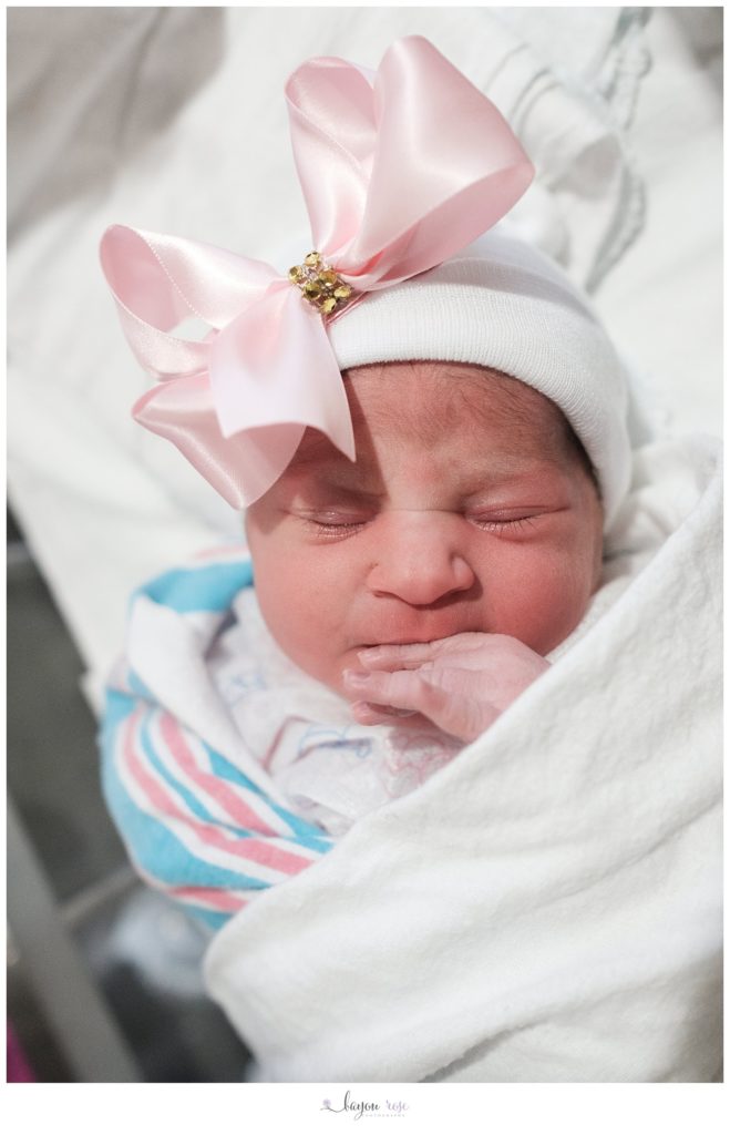 image of newborn baby girl wearing pink bow