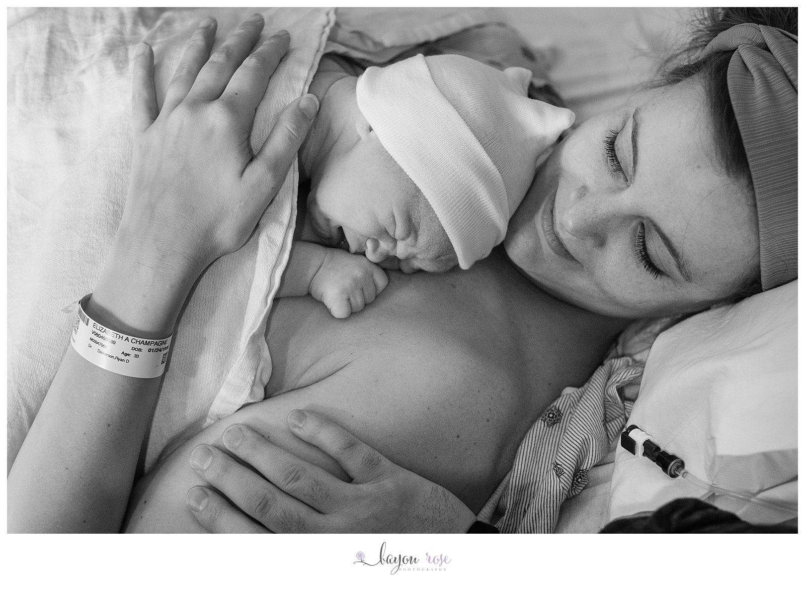 newborn rainbow baby rests of mom's chest while dad holds mom