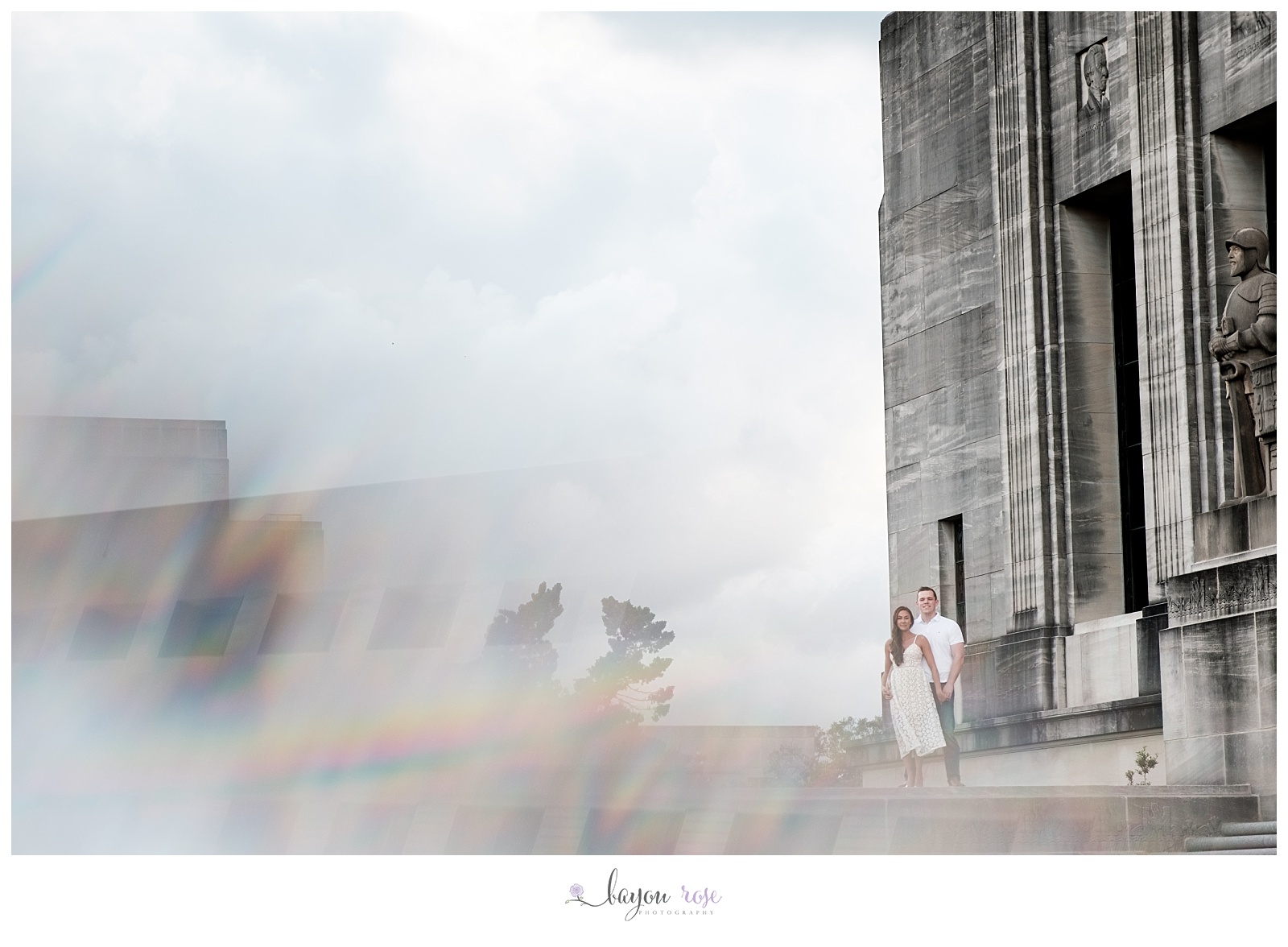 rainbow reflection on engaged couple standing on Baton Rouge capitol building