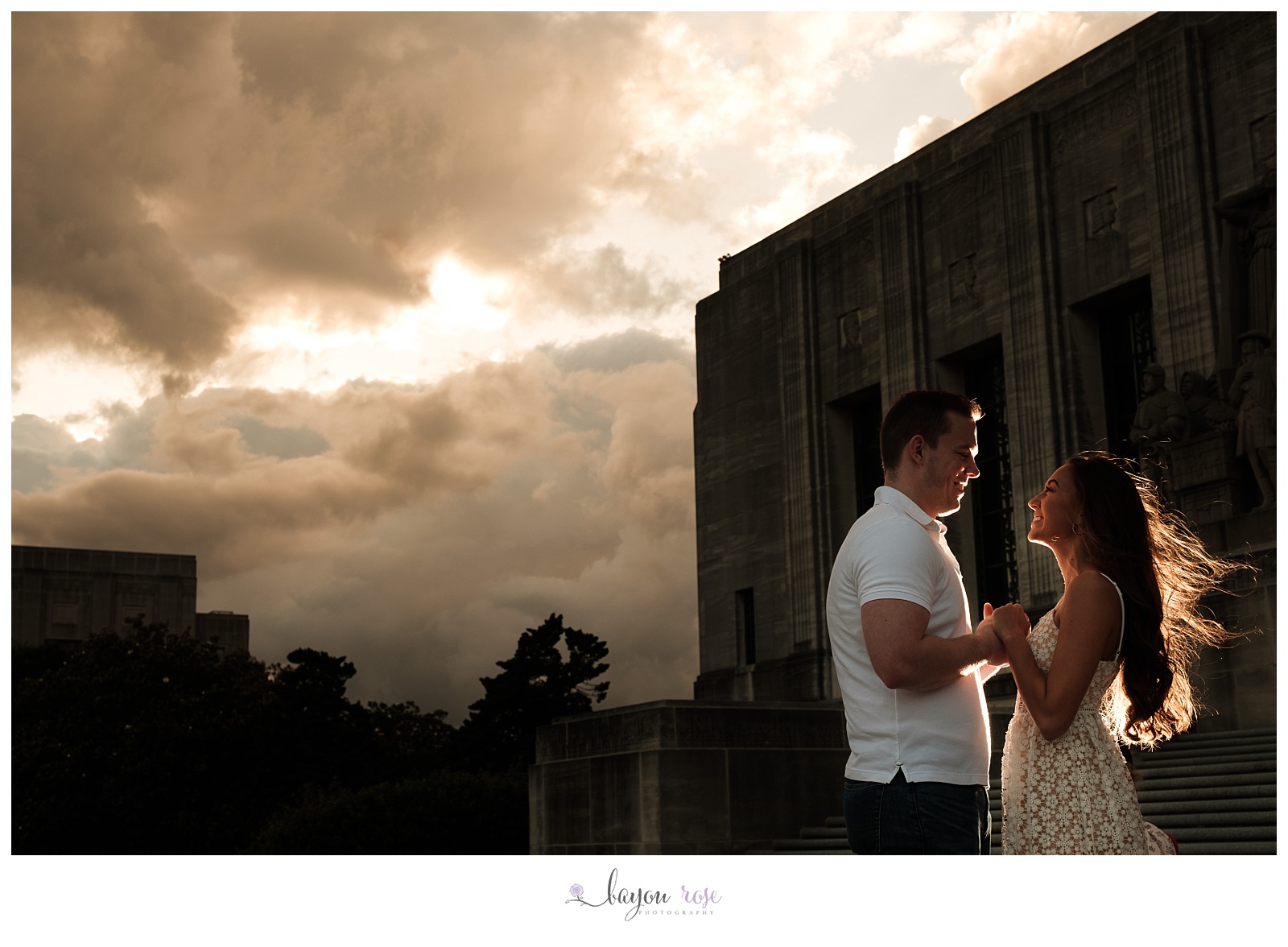 engaged couple silhouetted against storm clouds