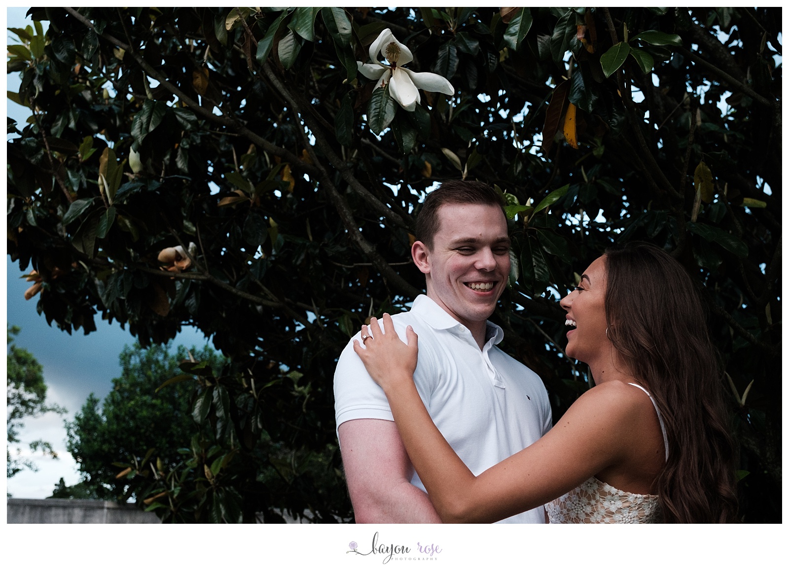 couple laughing infront of magnolia tree
