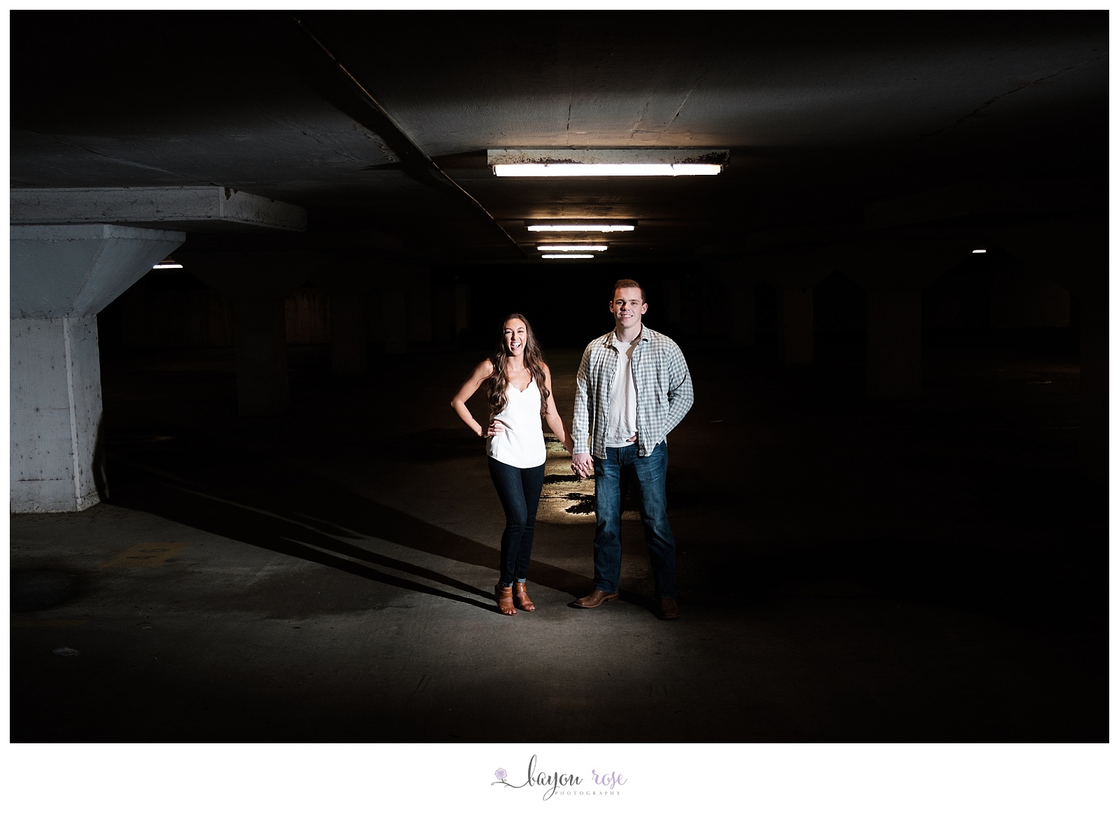 woman laughing as couple poses in parking garage