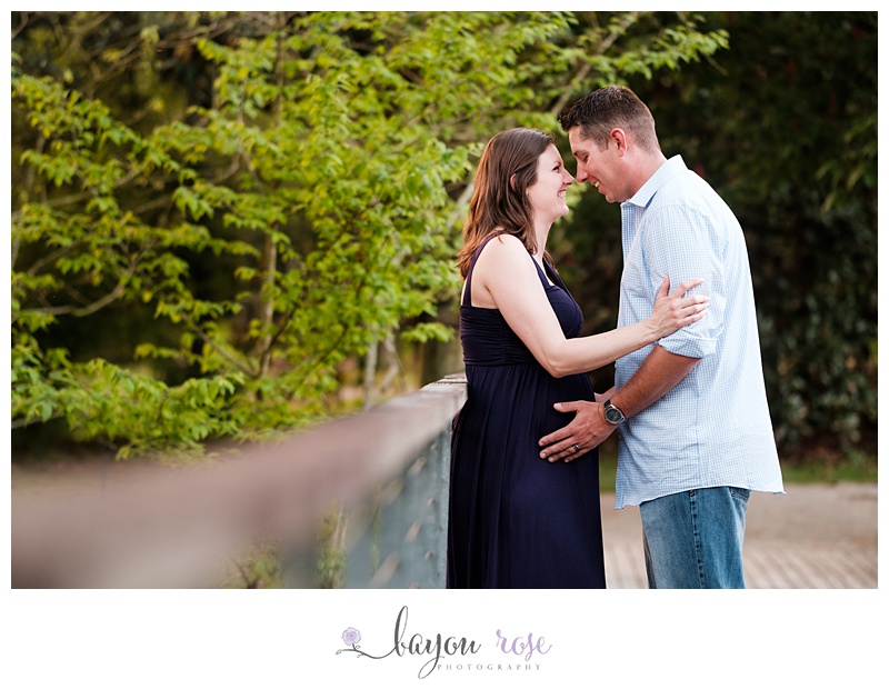 Pregnant woman and husband on bridge with greenery
