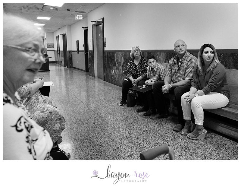 family sits on benches while waiting anxiously for adoption to begin