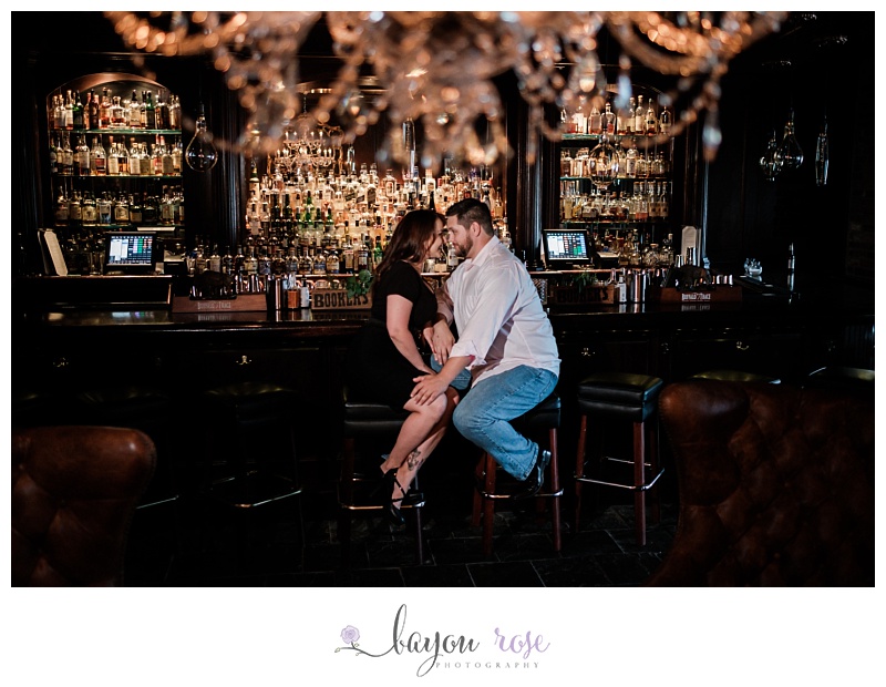 couple posing under chandelier in whiskey bar