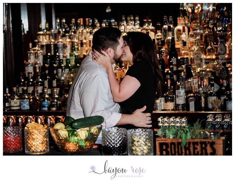 couple kissing behind whiskey bar