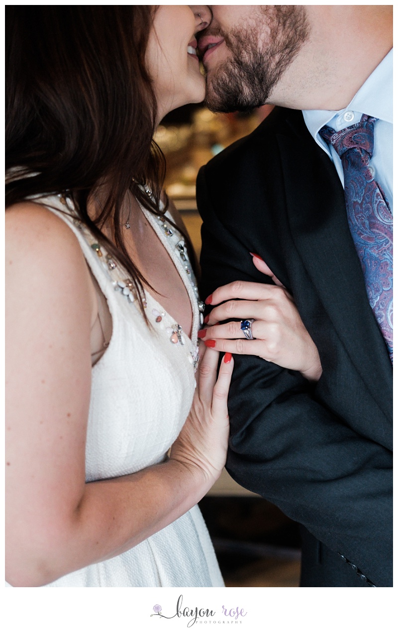 image of couple kissing with engagement ring showing