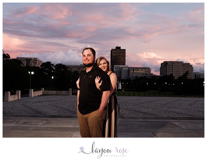 man and woman pose against sunset in downtown Baton Rouge