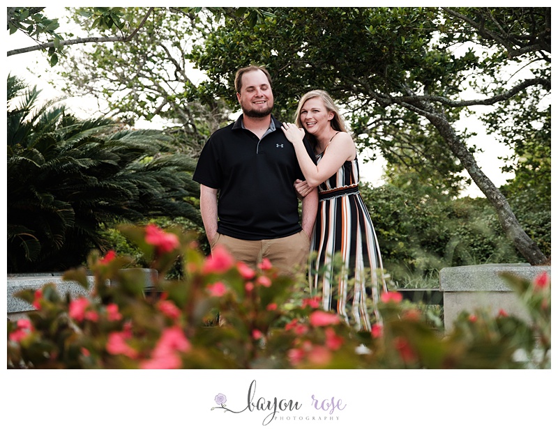 Couple laughs while posing for image in garden