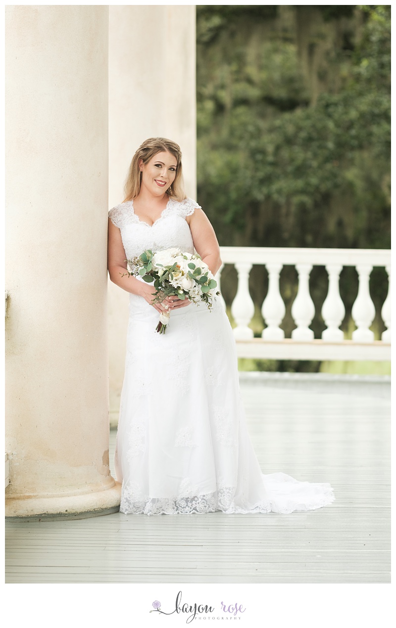 Bride in wedding dress holding flowers on porch