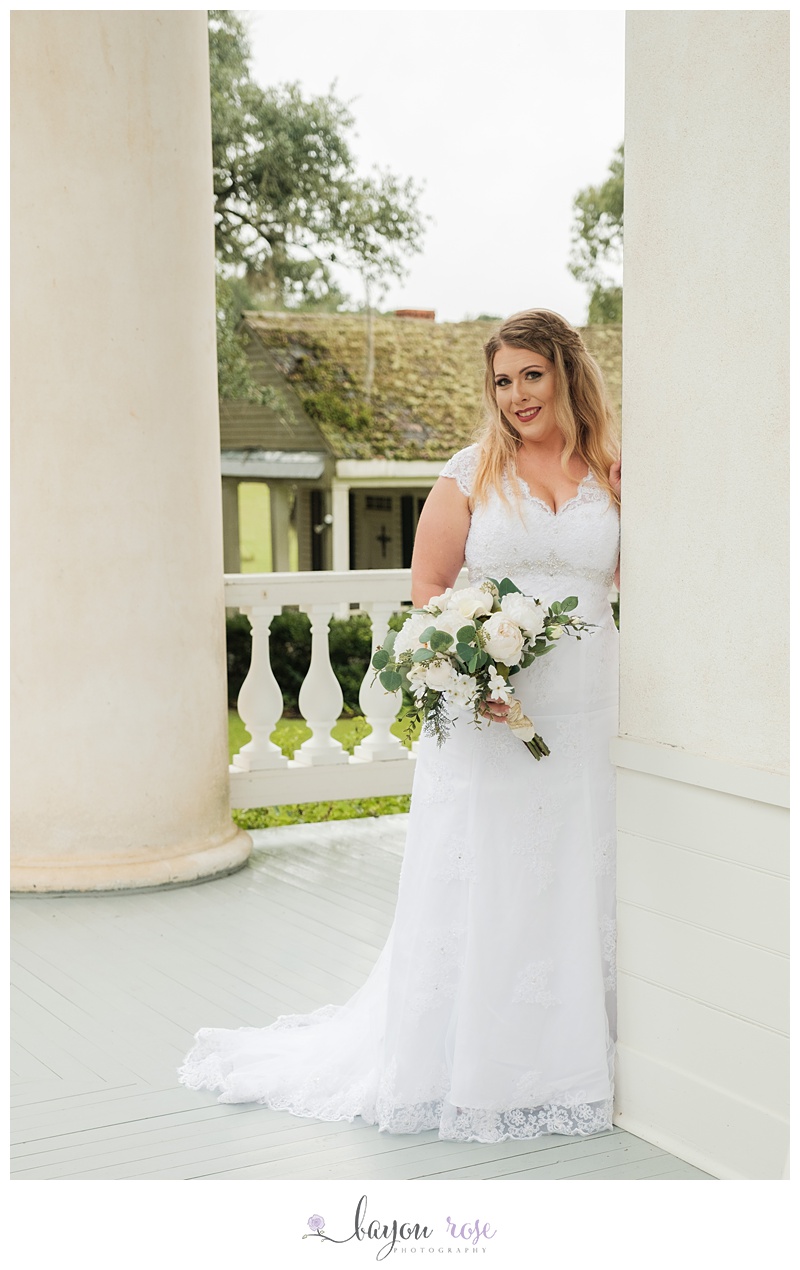 Bride on porch with chapel in background