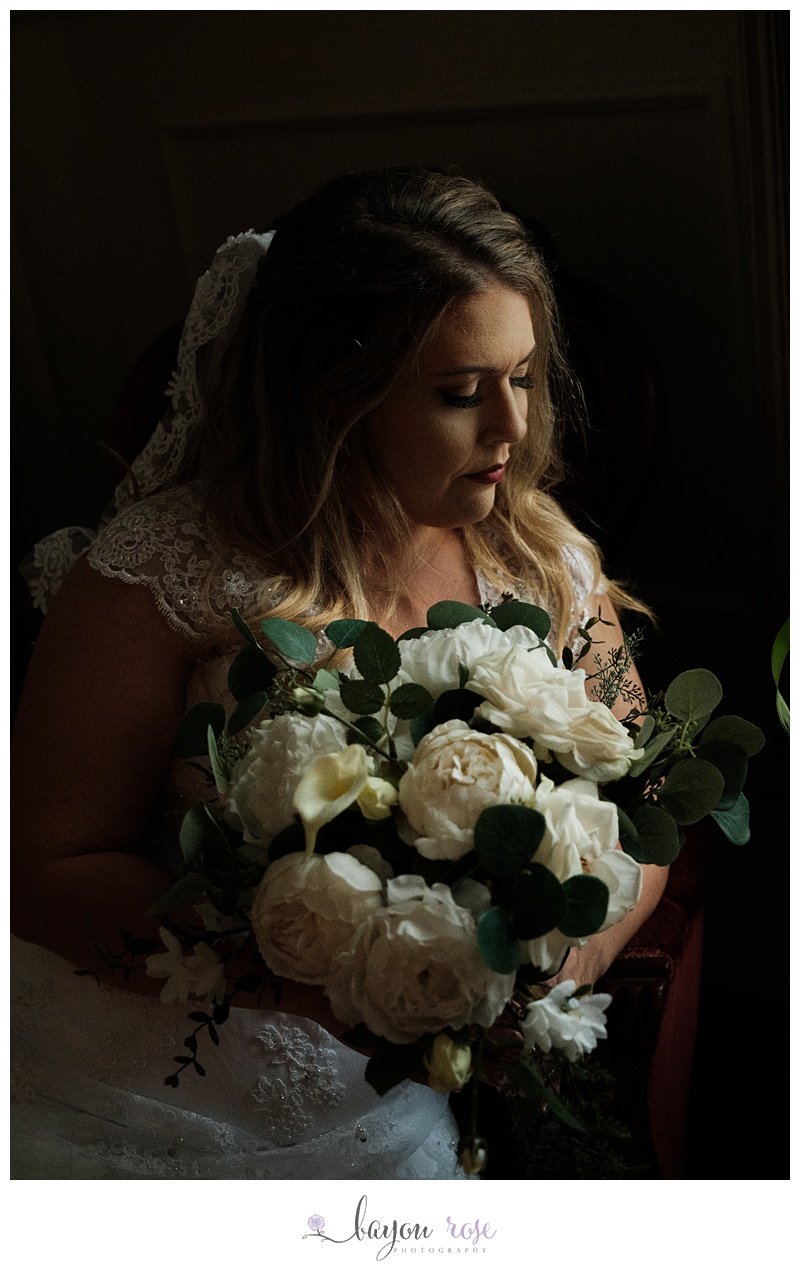 Image of bride in shadow holding flowers, at Greenwood Plantation