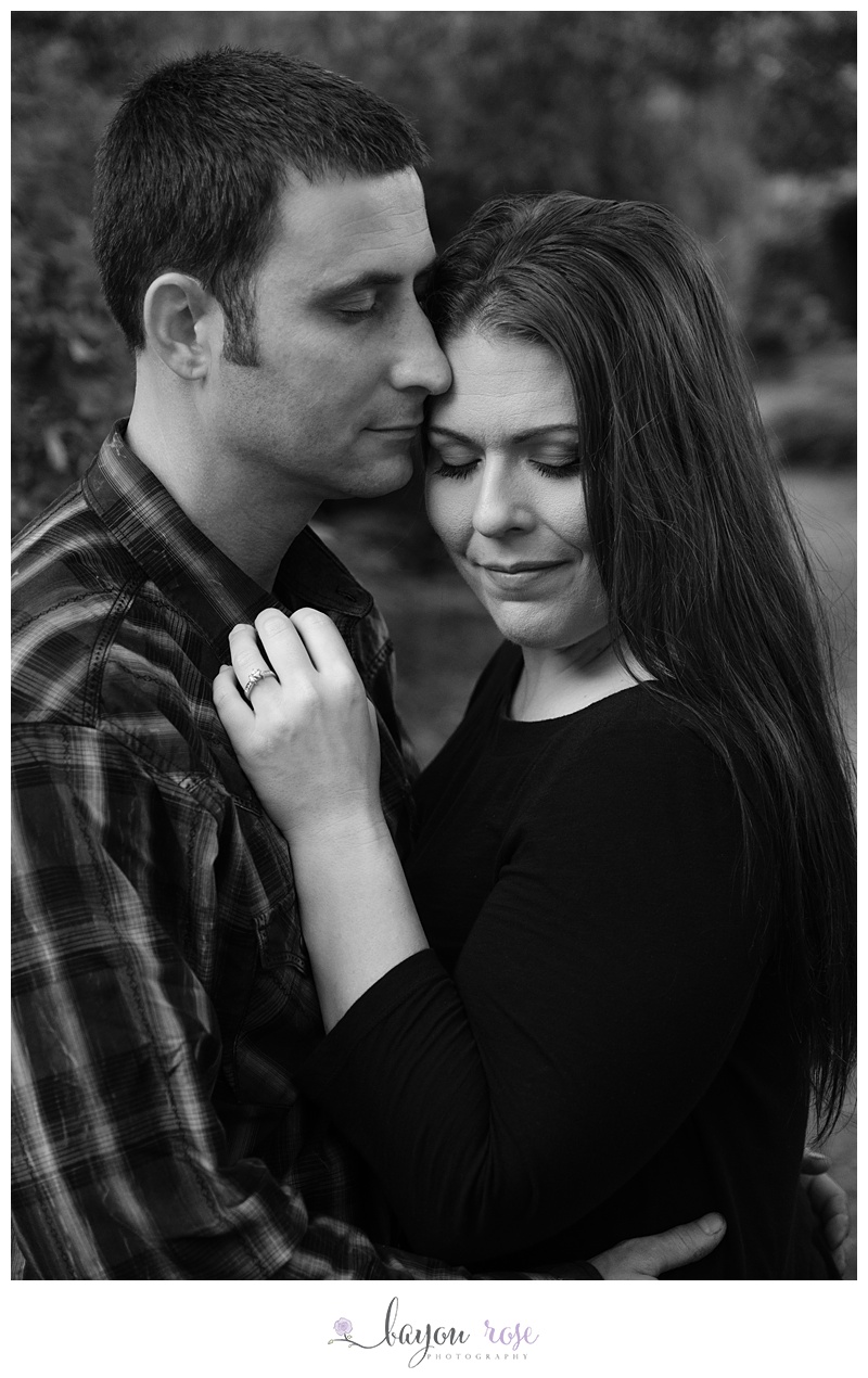 man and woman snuggling in black and white outdoor image