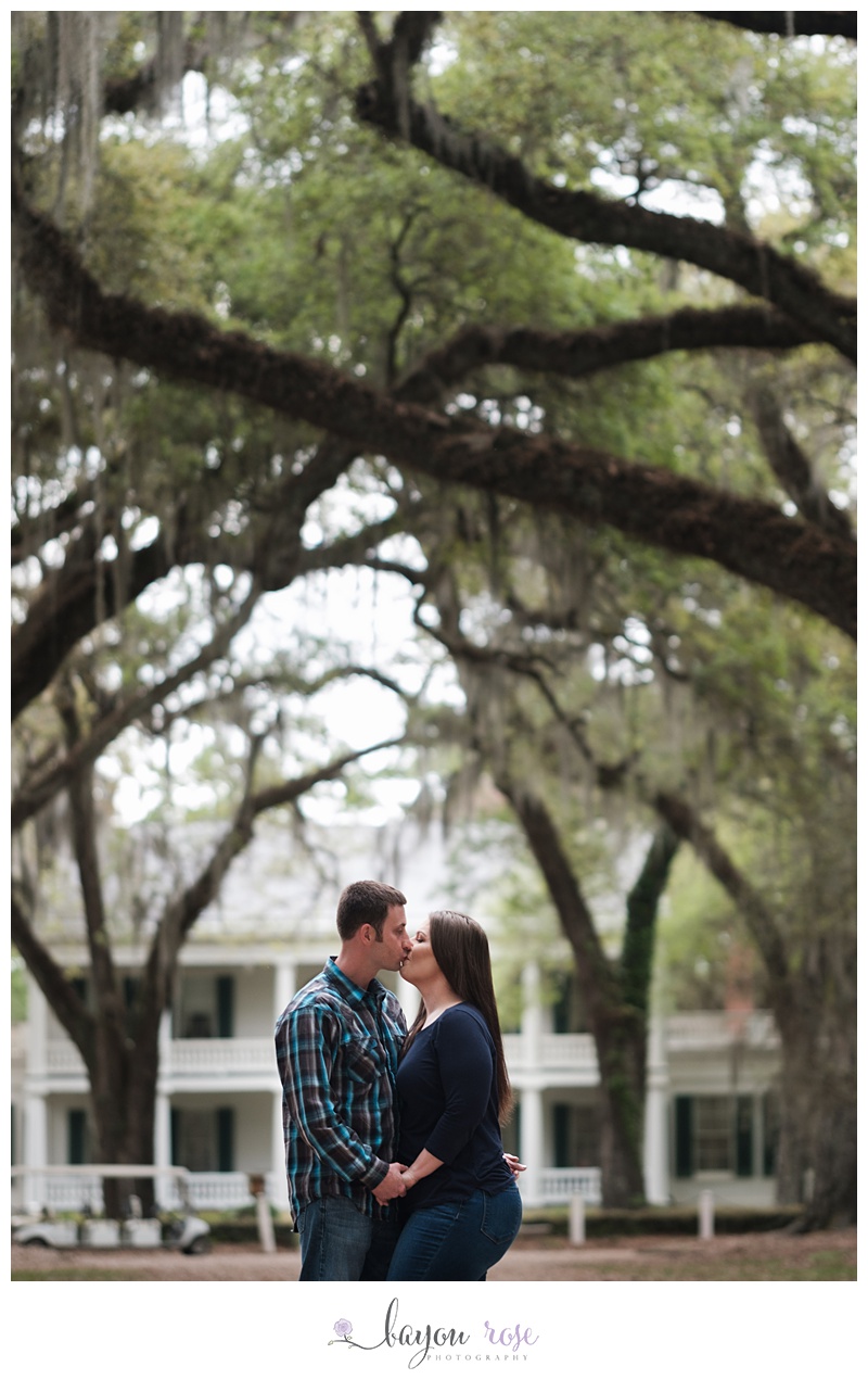couple kissing under trees and Spanish moss