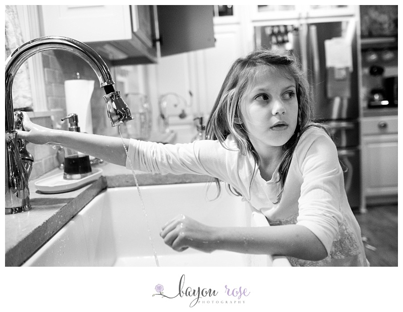 Girl washes hands at kitchen sink