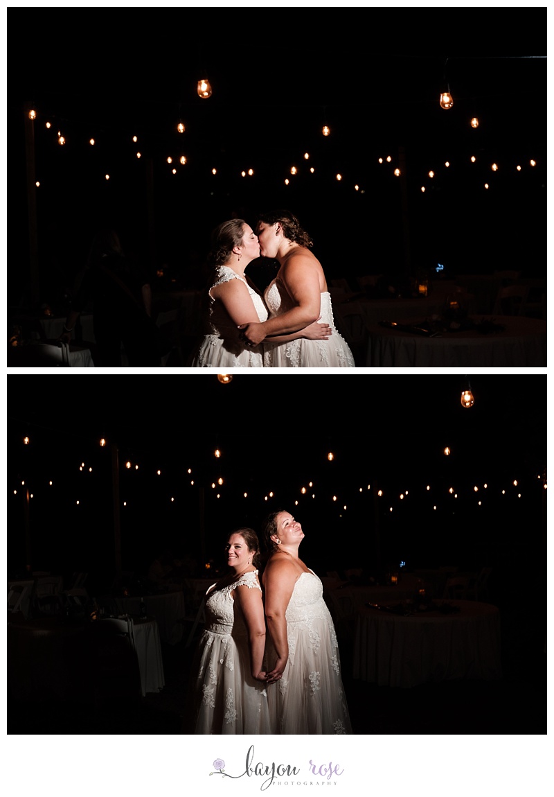 LGBTQ brides kissing under string lights at night on Pensacola beach after wedding