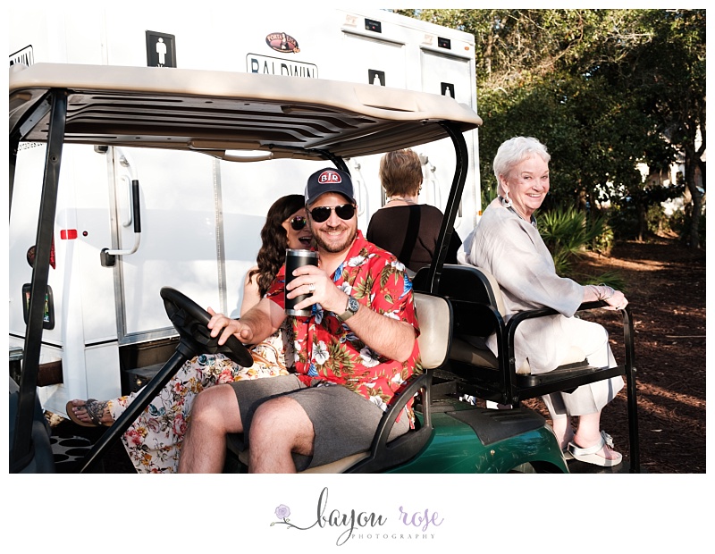 guests riding in golf cart while holding beer