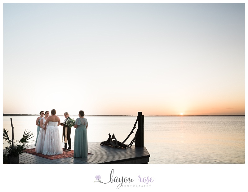 two LGBTQ brides on dock at sunset