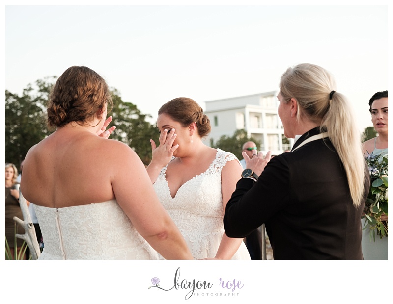 two brides wiping away tears during ceremony