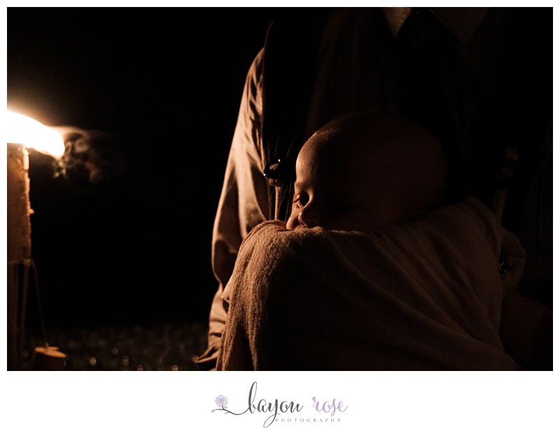 candle light portrait of baby in sling