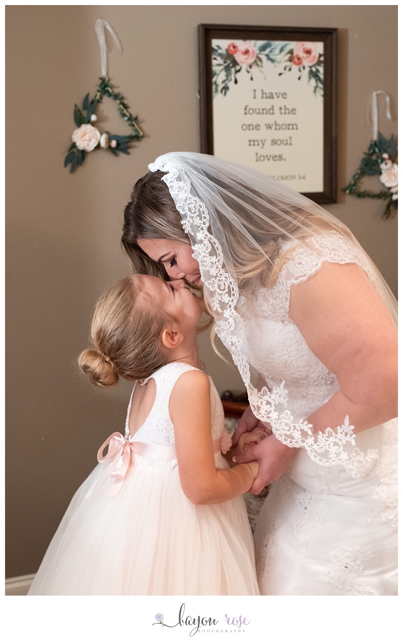 bride and daughter eskimo kiss before ceremony