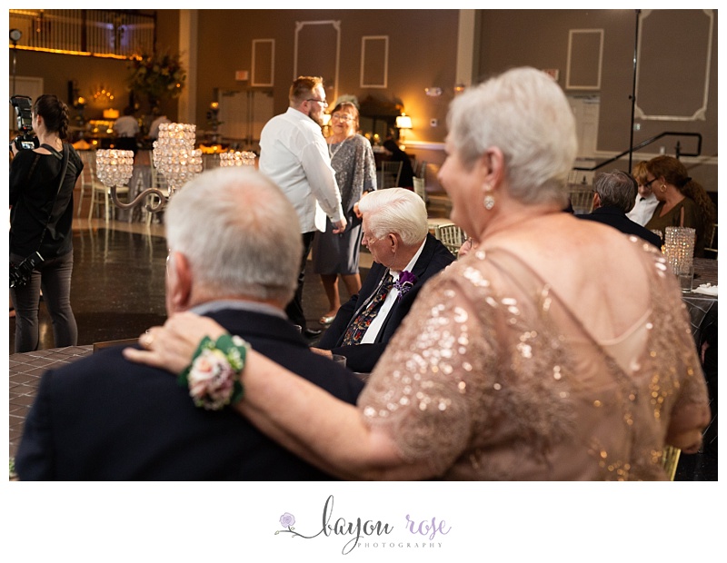 grandfather looks on as bride dances