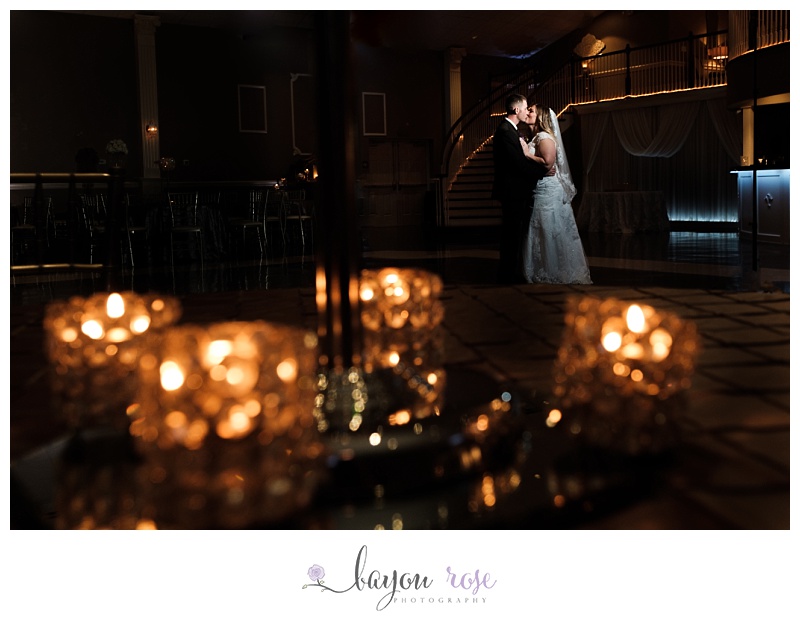 artistic wedding photograph of bride and groom photographed through candles