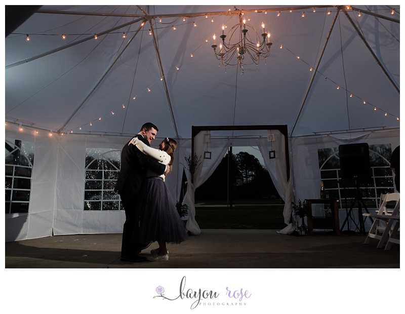 bride and groom first dance under chandelier
