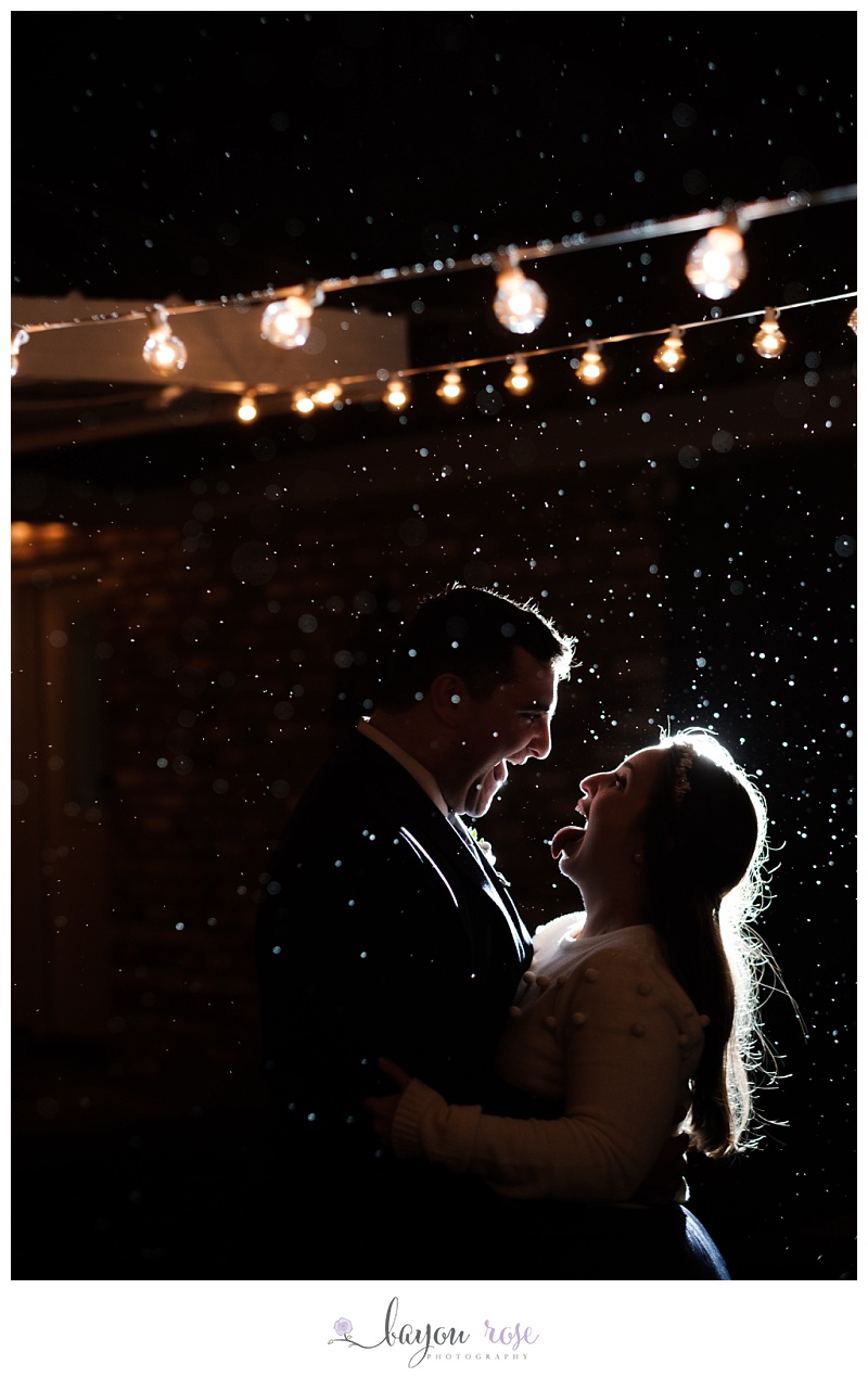 bride and groom lit up during rain storm in Baton Rouge intimate wedding image