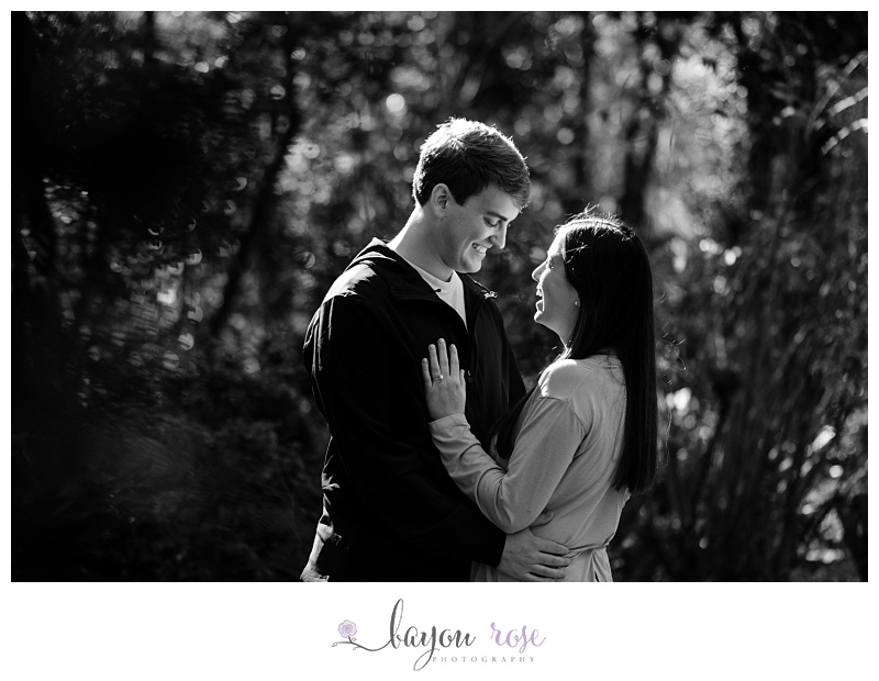 black and white image of engaged couple laughing in sunlight at Windrush Gardens