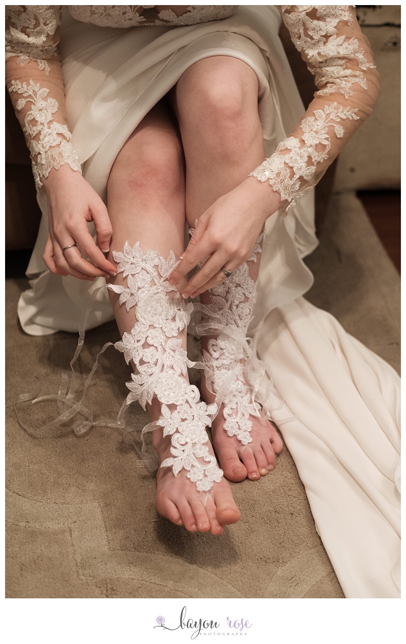 bride lacing up lace leg covers under wedding dress in The Gatehouse's bridal room