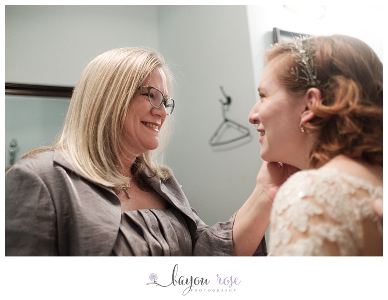 Mother of the bride patting bride's cheek after getting ready
