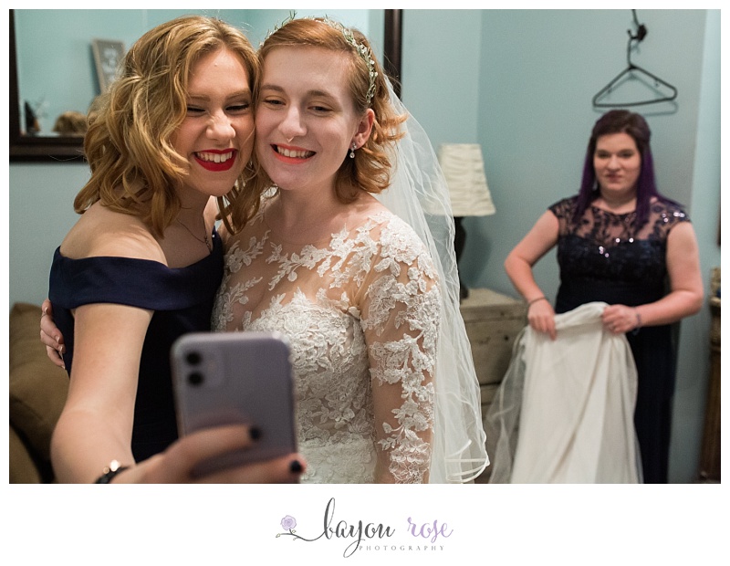 sisters taking selfie in wedding clothes
