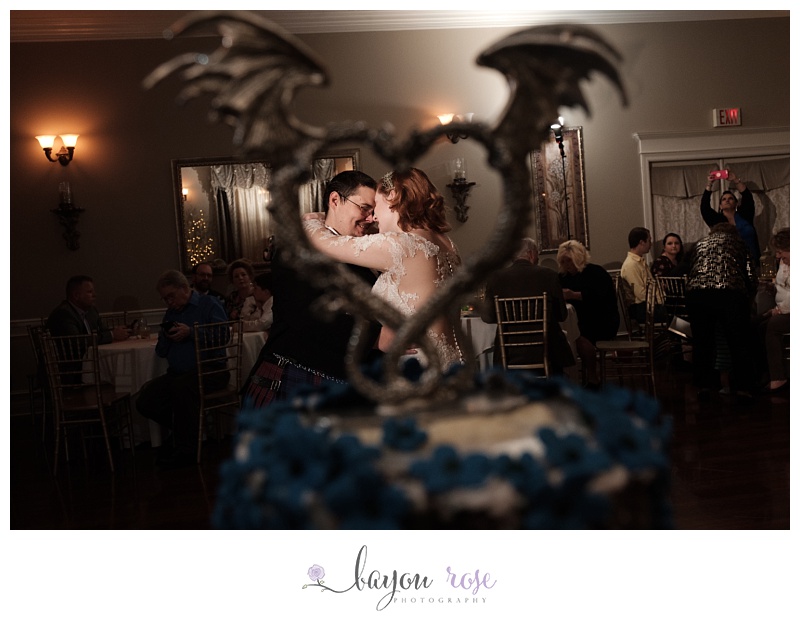 unique first dance photo of couple framed in dragon cake topper