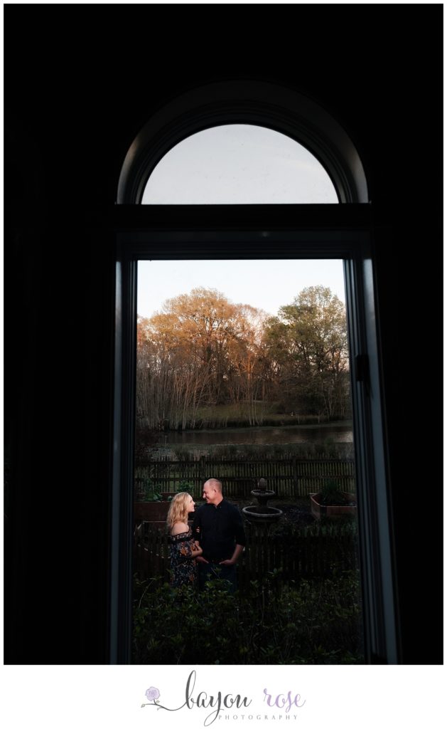 creative engagement photo of couple framed in window of their home