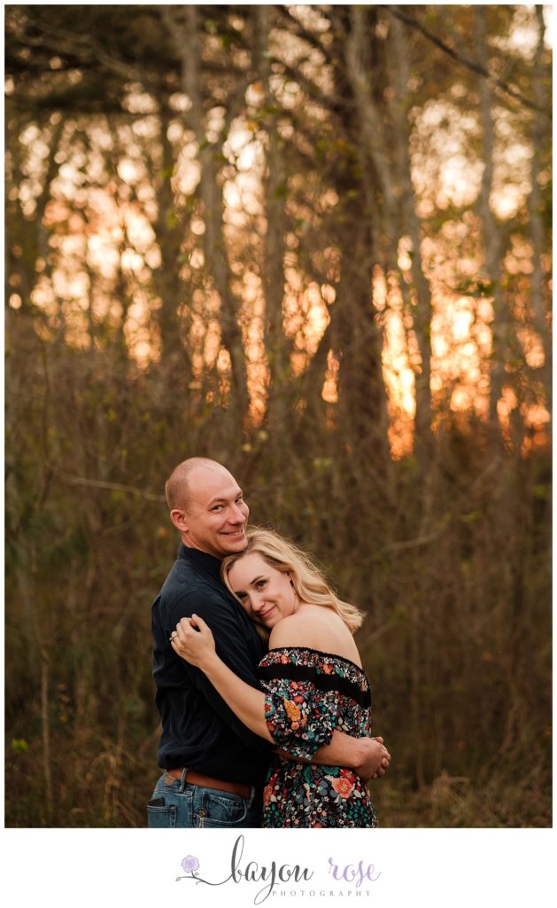 couple hugging in front of trees at sunset in Baton Rouge