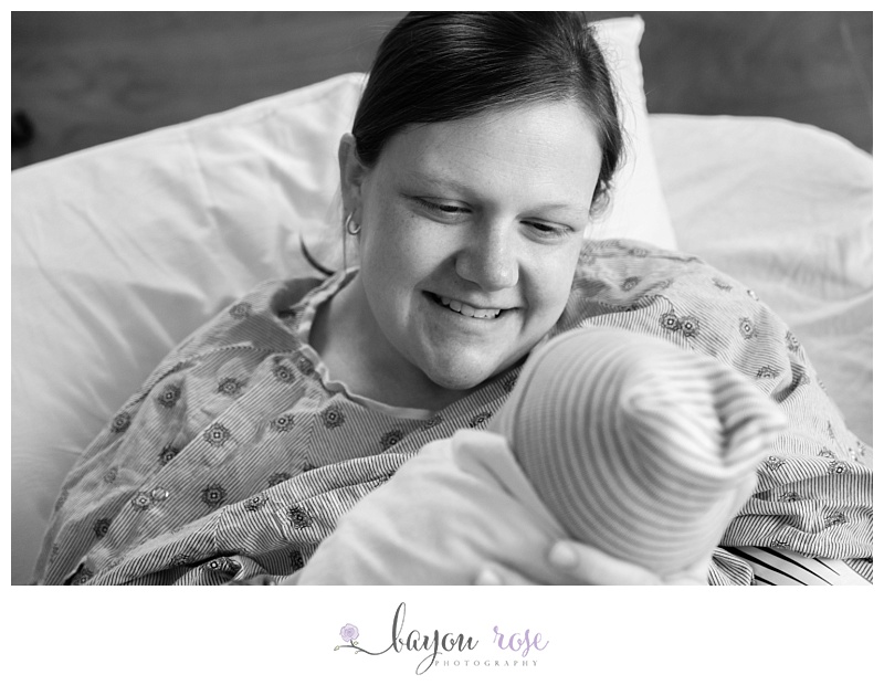 mom smiling at newborn baby boy at Woman's Hospital