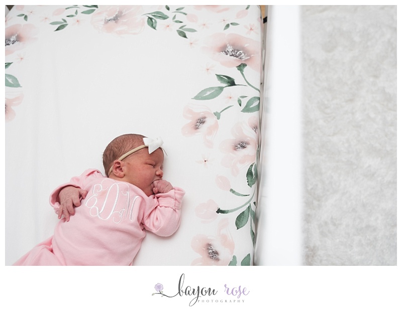 newborn baby girl in crib with flower sheets