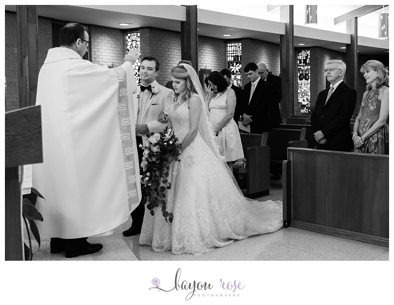 Groom sneaking look at bride during Baton Rouge elopement ceremony at St. Joseph
