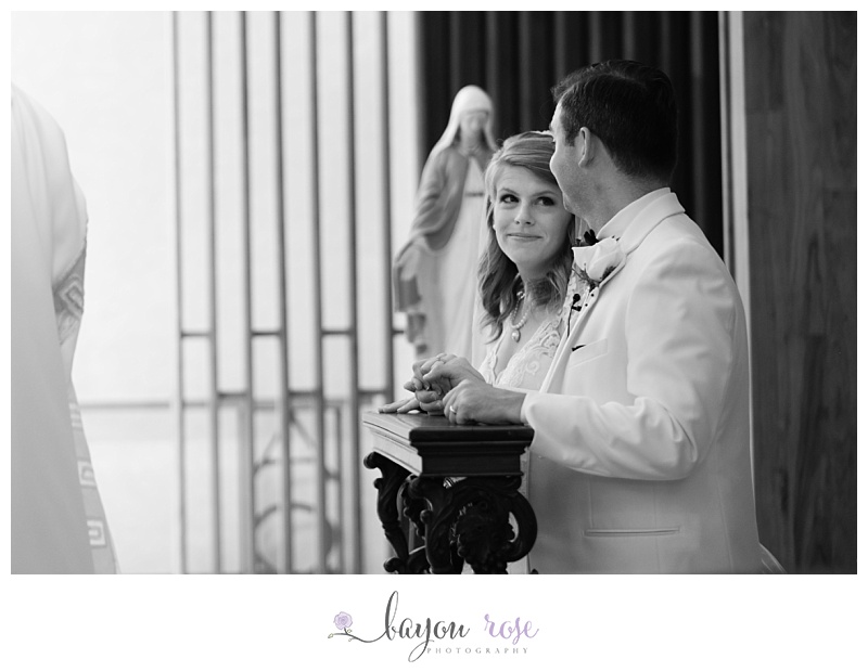 bride sneaks groom a look during Catholic wedding elopement ceremony at St Joseph