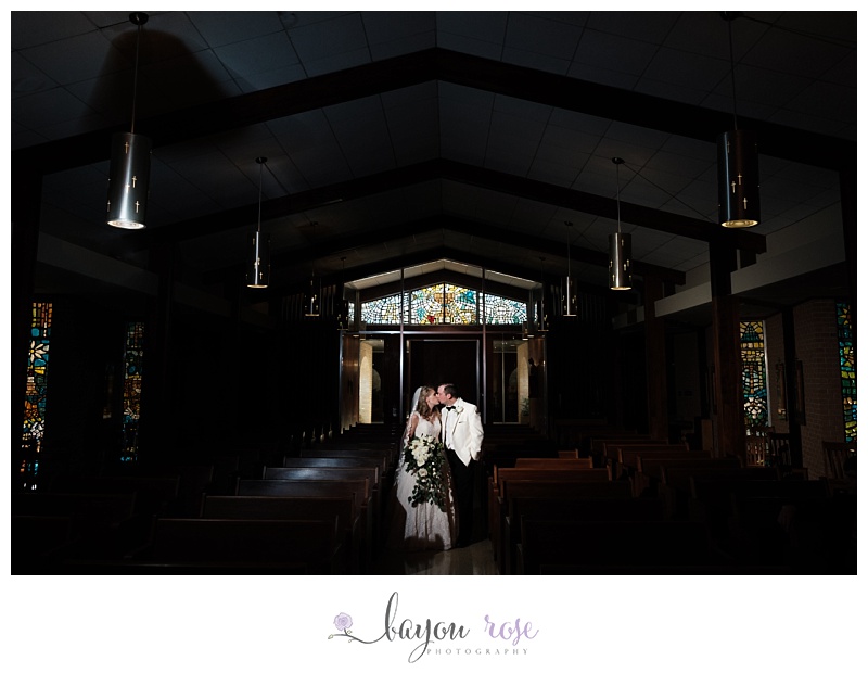 bride and groom kissing under stained glass of St Joseph in Baton Rouge elopement photographer