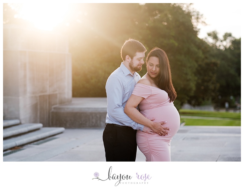 dawn maternity photographer with sun flare in downtown Baton Rouge