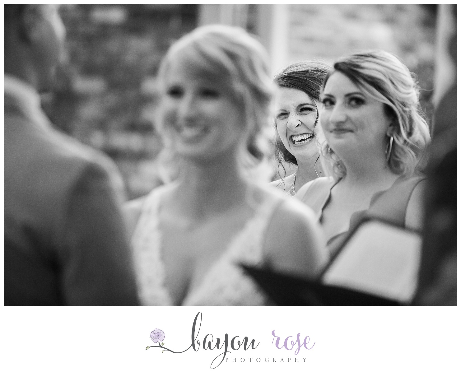 Bridesmaid looks on at bride and groom and cries as she laughs during the vows