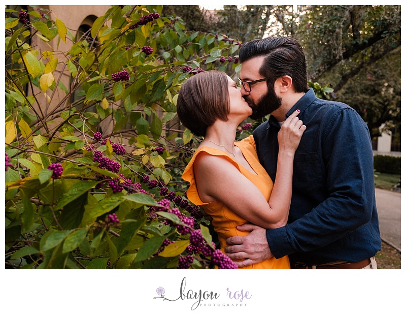 Couple kissing near bushes with berries on LSU campus