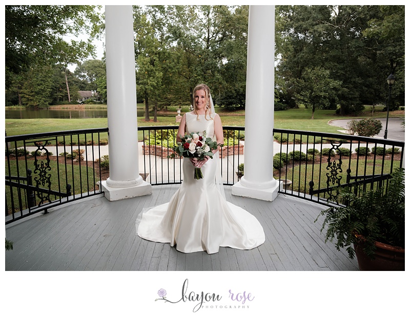 Bride smiling on porch in Baton Rouge