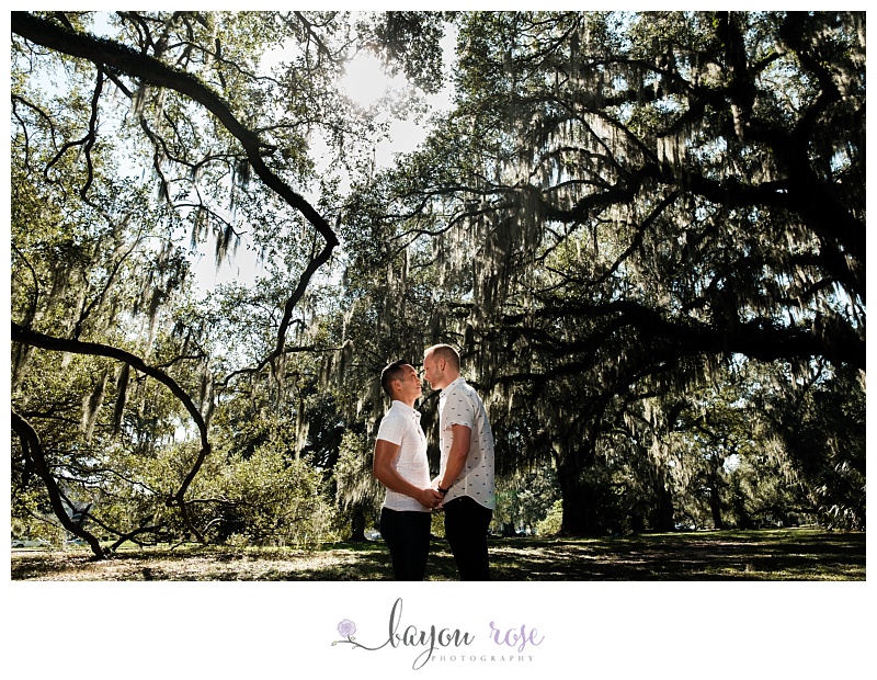 Gay engagement photo under Spanish moss in City Park New Orleans