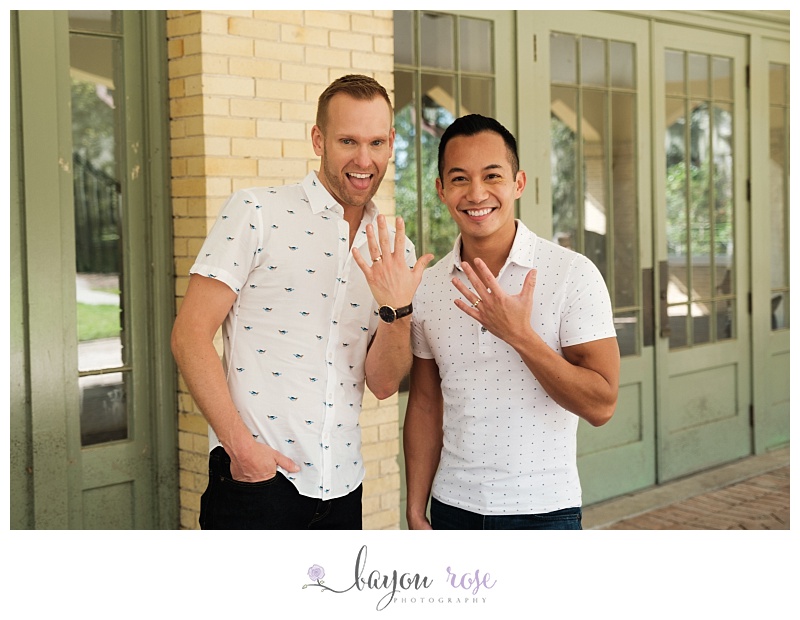 Engaged gay couple showing off engagement rings