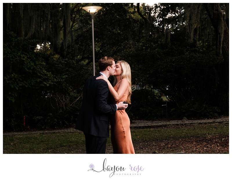 woman and man kissing in New Orleans Sculpture Garden after surprise proposal